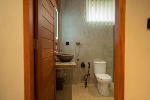 ein Badezimmer mit Toilette und Waschbecken in der Unterkunft Villa Trembesi in Kuta Lombok