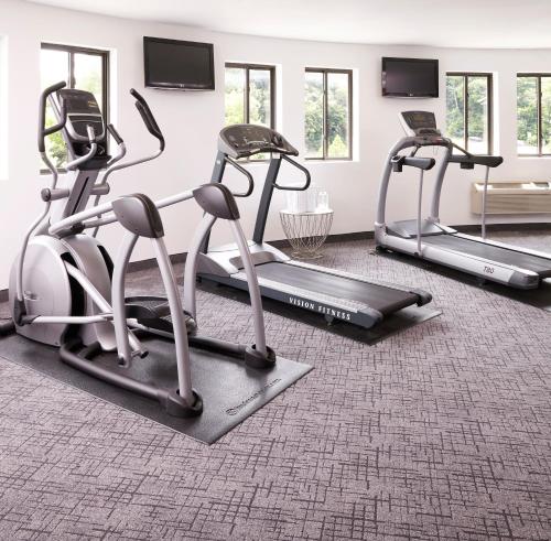 a gym with three tread machines in a room at The Royal Regency Hotel in Yonkers