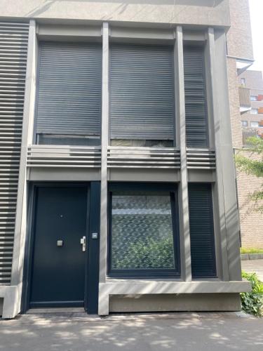 a building with a blue door and windows at Chambre privée Sdb kitchenette proche de Paris in Saint-Ouen