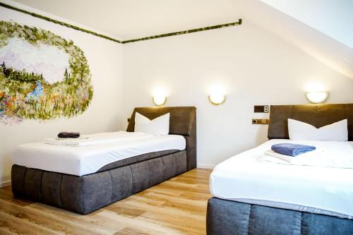 two beds in a room with white walls and wood floors at Smart Resorts B&B 2 BB2 328 in Winterberg