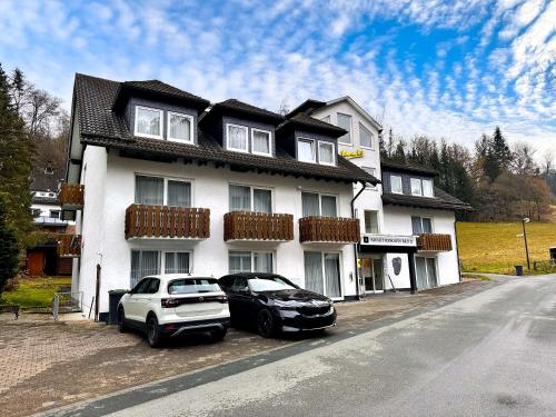 two cars parked in front of a white house at Smart Resorts B&B 2 BB2 328 in Winterberg
