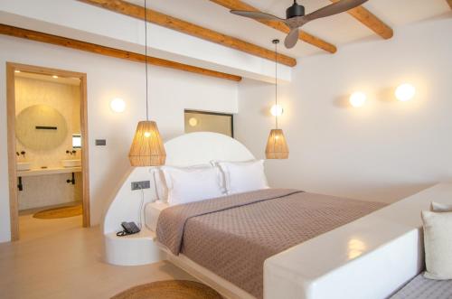 a bedroom with a large bed with two lamps at ARC suites in Mylopotas