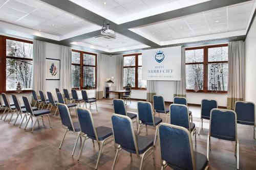 a conference room with chairs and a screen with a presentation at Hotel Aubrecht Country Spa Resort in Przechlewo