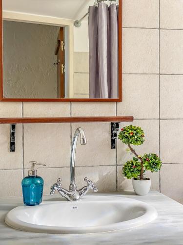 a bathroom sink with a blue candle and a mirror at Kyparissis Beach House 2 in Skala Mistegnon