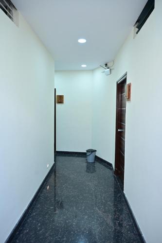 an empty room with a white wall and a door at Address Residency Mysuru in Mysore