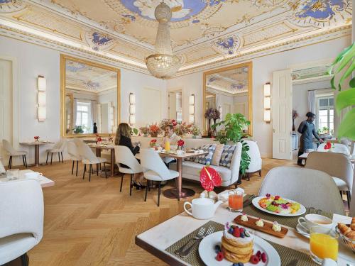 a restaurant with people sitting at tables in a room at The One Palácio da Anunciada in Lisbon