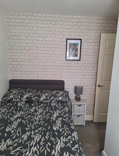 a bedroom with a bed and a brick wall at Hertfordshire in Letchworth