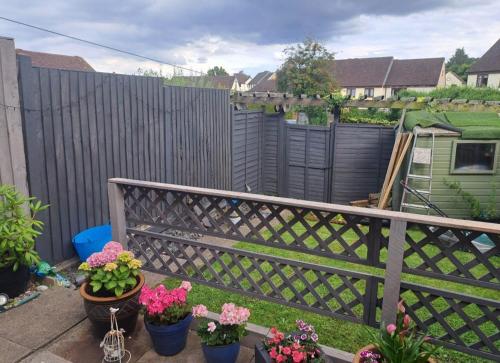 a balcony with potted flowers and a fence at Hertfordshire in Letchworth