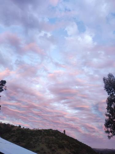 a view of a cloudy sky with a hill at Estancia Don Domingo in Hualañé