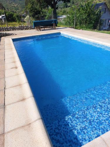 a blue swimming pool with a bench in the background at Estancia Don Domingo in Hualañé