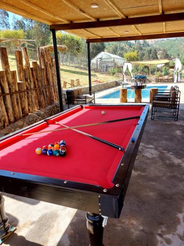 a pool table in front of a swimming pool at Estancia Don Domingo in Hualañé