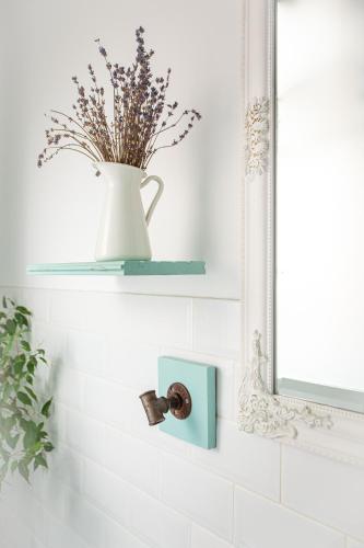 a bathroom with a vase on a shelf and a mirror at Vânători Nest - 2 room - Pumo properties in Bucharest