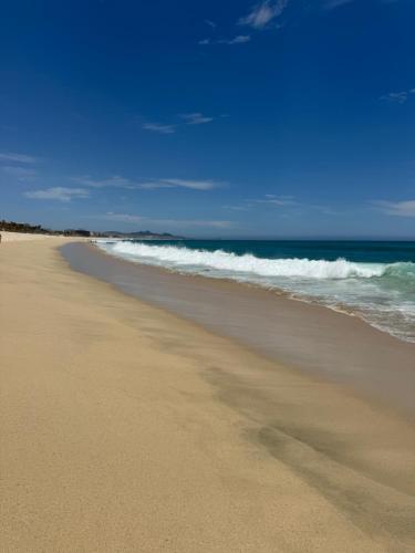 a beach with the ocean and the waves at Beach front beautiful one bedroom Condo in San José del Cabo
