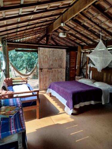 a bedroom with a bed and a hammock in it at Cabana do Tarzan na Praia de Parati Mirim in Paraty