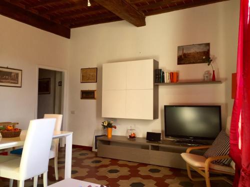 a living room with a television and a table with chairs at Casa Emilio in Siena
