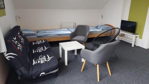 a room with a bed and two chairs and a table at Apartmány Kousek od jezera in Doksy