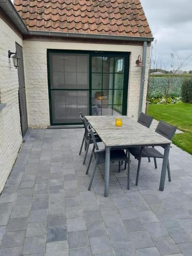a wooden table and chairs on a patio at Vakantiehuis Schardauw in Damme