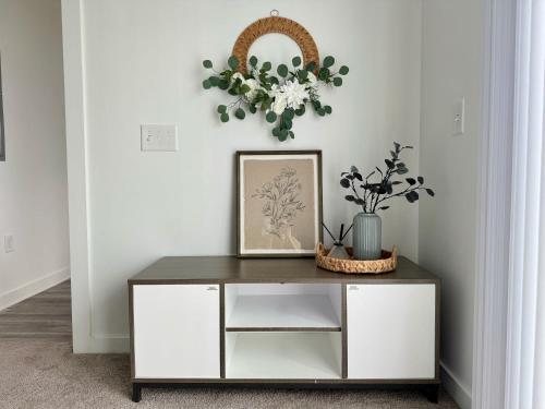 a console table with a picture and flowers on it at Luxury 1B1B with Balcony Downtown 542Blvd302 in Atlanta