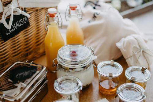 a table with jars of honey and a basket of juice at Weingarten-Resort Unterlamm Loipersdorf - ADULTS ONLY in Unterlamm