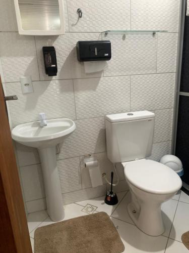 a small bathroom with a toilet and a sink at Kitnet da Paty in Praia do Forte