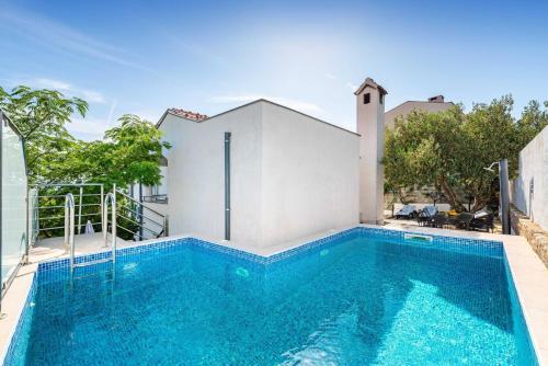 a swimming pool in front of a house at MY DALMATIA - Sea view apartment Dajana with private pool in Maslenica