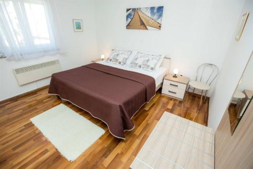 een slaapkamer met een groot bed en een houten vloer bij MY DALMATIA - Apartment ViGo with private pool in Bokanjac