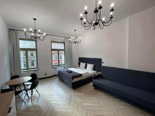 a bedroom with a bed and a couch and a table at Pod Błękitnymi Podkowami in Wrocław
