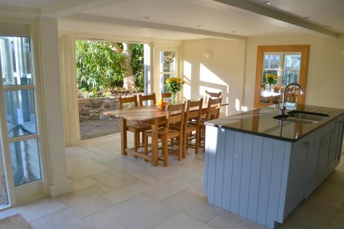 a kitchen and dining room with a table and chairs at Pear Tree Cottage in Shaldon