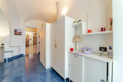 a kitchen with white cabinets and a blue tile floor at Open space letto Queensize con vista doccia in Cava deʼ Tirreni