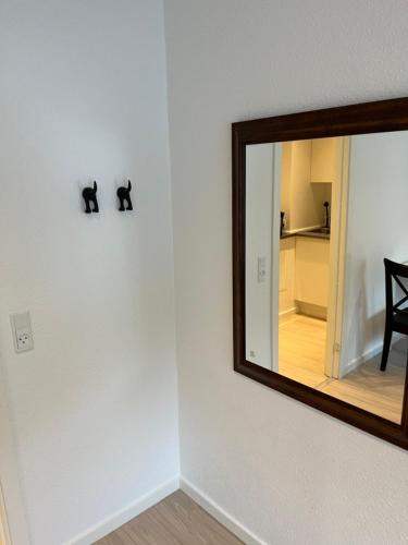 a mirror and a black cat on a wall at Billund Mini hostel room 4 - Tæt på LEGOLAND og LEGO HOUSE in Billund