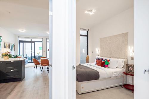 a bedroom with a bed and a desk and a room at Elegant 2 Beds, 2 Baths Flat with Private Terrace, High-End Finishes and Chic Furnishings in London