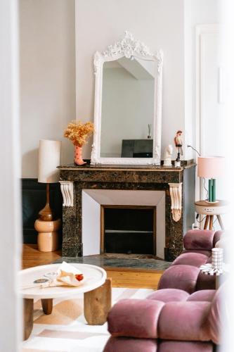 un salon avec une cheminée et un miroir dans l'établissement Le Mademoisel' - 2 pièces - Haut de Gamme - Capitole, à Toulouse