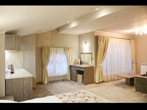 a bedroom with a bed and a desk and a window at Хотел ЛОНДОН in Svilengrad