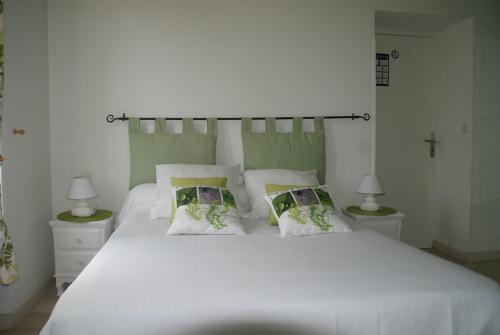a bedroom with a large white bed with two pillows at Hotel de Got in Villandraut