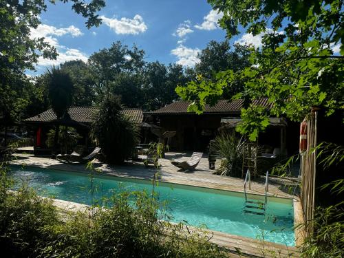 une piscine dans la cour d'une maison dans l'établissement Au Bois Flotté, à Hourtin