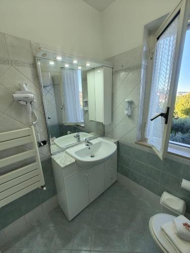 a white bathroom with a sink and a mirror at Mia Domus Guest Holiday in Ciampino
