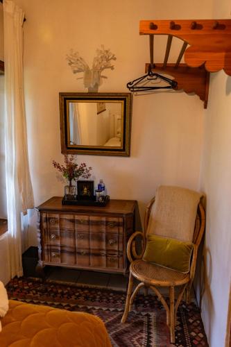 a room with a chair and a dresser and a mirror at Sionsberg Farmstay in Riversdale