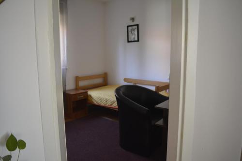 a small room with a bed and a chair at Apartman Pirot in Pirot