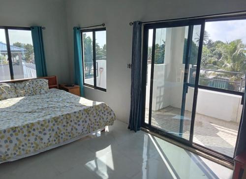 a bedroom with a bed and a large window at Dove Escapes- 2 bdrm appt in village of Placencia in Placencia Village