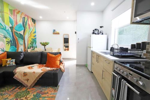 a living room with a black couch in a kitchen at Rooftop Retreat on Ocean Drive with Beach View in Miami Beach