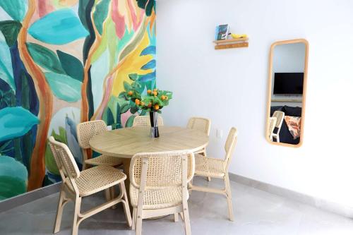a table with chairs and a vase with flowers at Rooftop Retreat on Ocean Drive with Beach View in Miami Beach