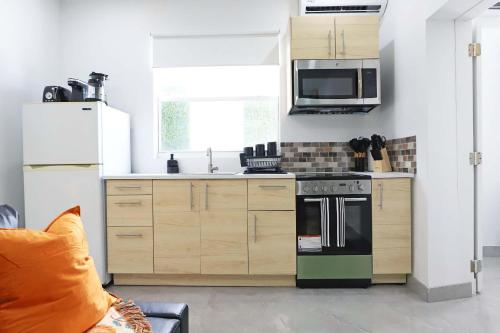 a kitchen with wooden cabinets and a stove top oven at Rooftop Retreat on Ocean Drive with Beach View in Miami Beach