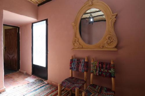a room with two chairs and a mirror on the wall at Gite Ogog Tacheddirt in Tacheddirt