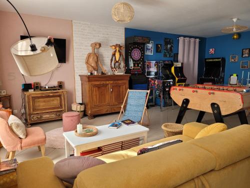 - un salon avec un canapé et un billard dans l'établissement Années 80, enquête et jeux hors du temps, à Saint-Romain-le-Preux