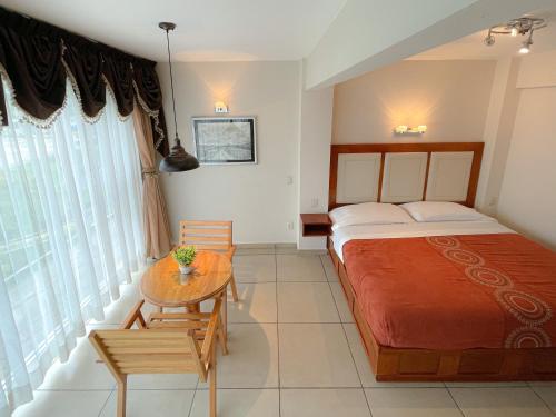 a bedroom with a large bed and a table at Hotel Fandangos Nochixtlán in Asunción Nochixtlán