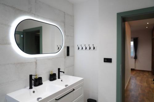 a bathroom with a white sink and a mirror at Chalupa Velká Javorská in Žandov
