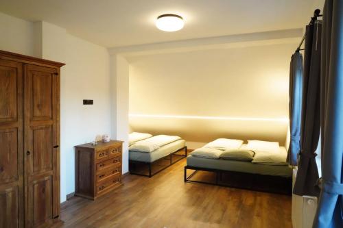 a room with two beds and a dresser at Chalupa Velká Javorská in Žandov