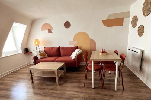 a living room with a red couch and a table at Le Terracotta - joli duplex centre ville in Cherbourg en Cotentin
