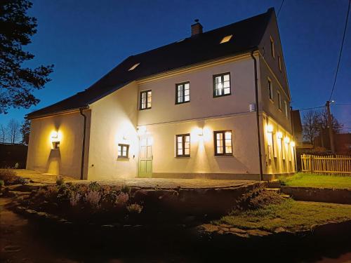 a large white house with lights on it at night at Chalupa Velká Javorská in Žandov