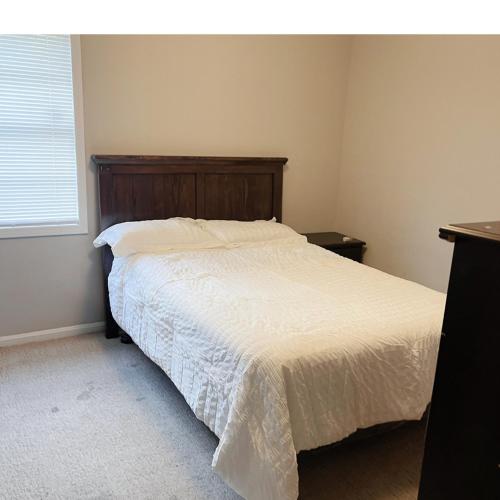 a bedroom with a bed with a wooden headboard at Comfortable Tuscaloosa Retreat in Tuscaloosa